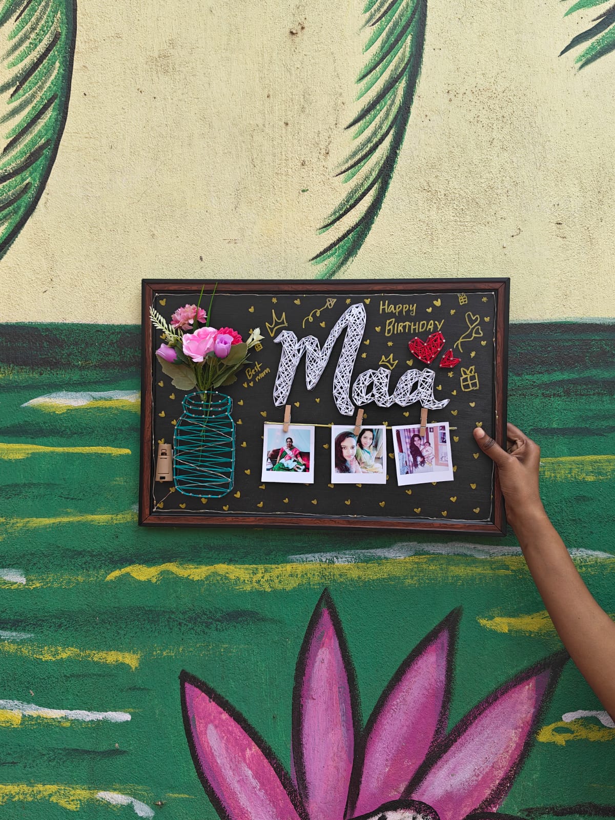 Maa thread art frame displayed against a colourful wall